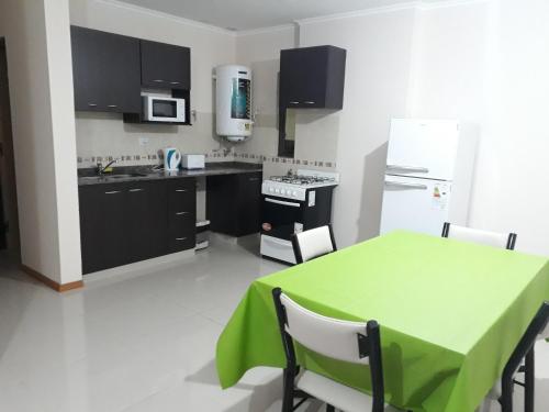 una cocina con mesa y mantel verde. en Departamento en Carlos Paz para familias, en Villa Carlos Paz