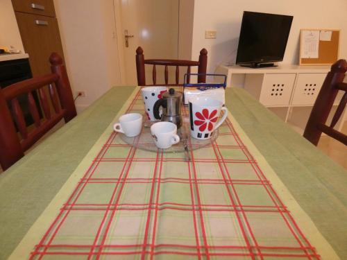 a table with two cups and a coffee maker on it at Maison d'O in Otranto