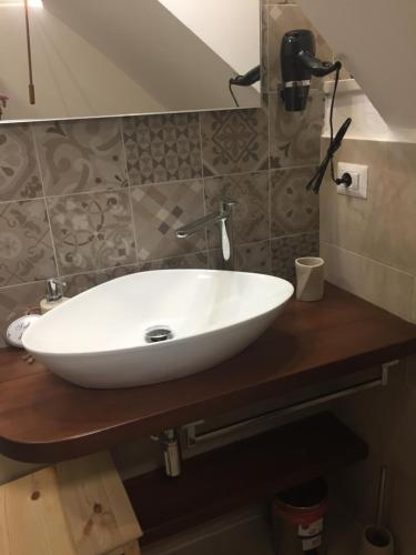 - un lavabo blanc sur un comptoir en bois dans la salle de bains dans l'établissement Le Casette Gargallo 2 - Ortigia, à Syracuse