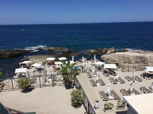 a group of lounge chairs and the ocean at Le Casette Gargallo 2 - Ortigia in Siracusa
