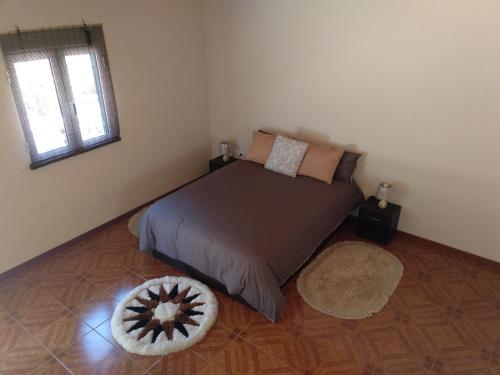 a bedroom with a bed and a rug at Danny's Rural Suite in Curral das Freiras
