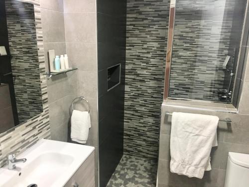 a bathroom with a sink and a toilet and a mirror at Appartement Luxe Marina Agadir in Agadir