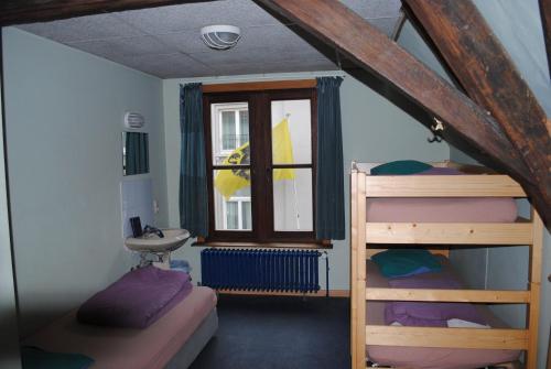 Charlie Rockets Youth Hostel في بروج: غرفة نوم بسريرين بطابقين ونافذة