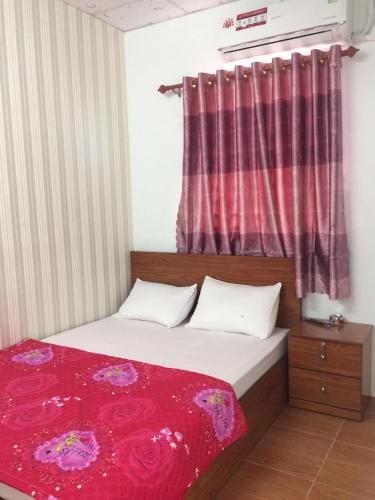 a bedroom with a bed with a red blanket at BangBang Motel in Can Tho