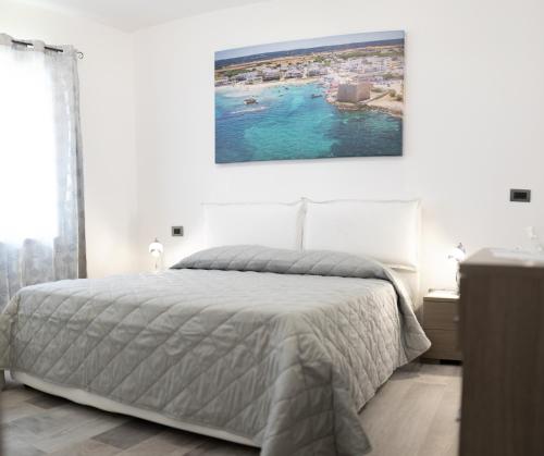 een slaapkamer met een bed en een schilderij aan de muur bij Casa Angela Rosa in Carovigno