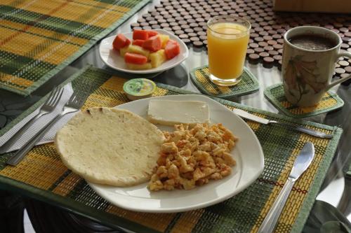 a table with a plate of food with bread and fruit at Mayorca Homestay in Medellín