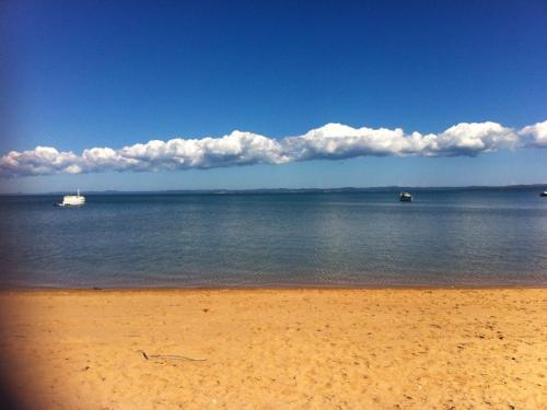 a beach with two boats in the water at Grand Mercure Allegra Hervey Bay in Hervey Bay
