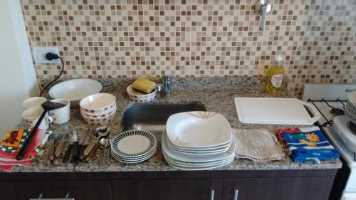 a kitchen counter with a sink and plates and a sink at Departamento Monoambiente Rivadavia in San Juan