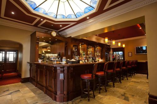 een bar in een restaurant met een glas-in-loodplafond bij Adair Arms Hotel in Ballymena