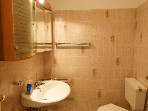 a bathroom with a sink and a toilet and a mirror at Haus Nordenlicht Ferienwohnung *Naujokat* in Wittdün