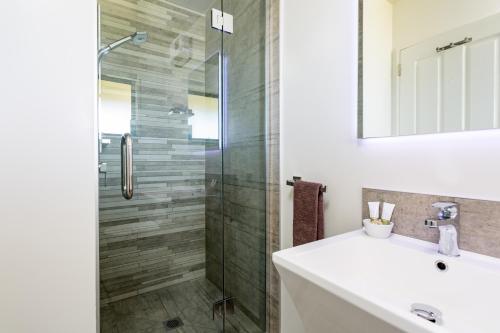 a bathroom with a sink and a shower at 8 on Oregon Boutique Lodge in Hanmer Springs