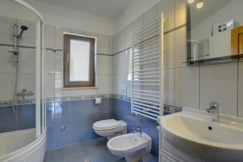 a bathroom with a white toilet and a sink at Villa Maria Betiga in Barbariga