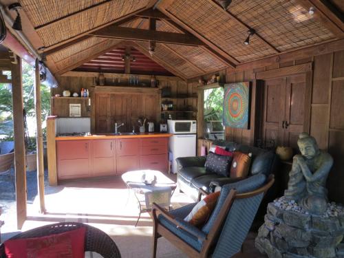 a living room with a couch and a kitchen at Bali Haven in Coromandel Town