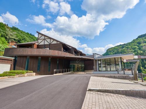 a large building with a road in front of it at Blue Villa Anabuki in Mima