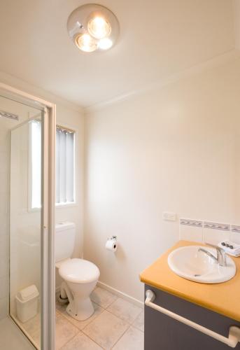 a bathroom with a toilet and a sink at Prom Gate Getaway in Yanakie