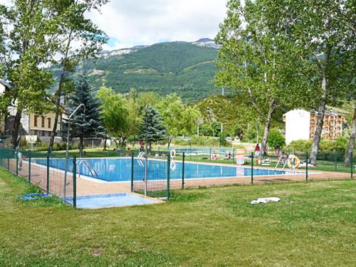 a swimming pool in a park next to a field at Apartamento MODESTO en las montañas del pirineo aragonés en Alquiler Altruista ECONÓMICO in Villanúa