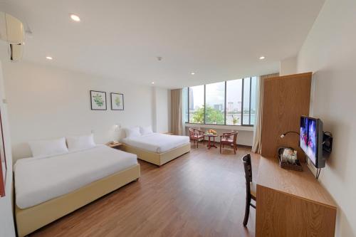 a hotel room with a bed and a living room at Vitalis Riverside Hotel in Danang