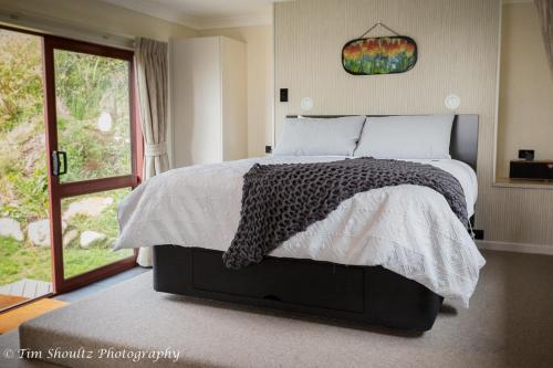 Postel nebo postele na pokoji v ubytování Whare Manu Boutique Cottage
