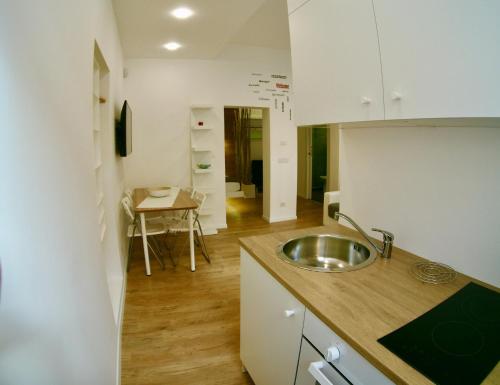 a kitchen with a sink and a table in it at Ragusa 2 al mare in Marina di Ragusa