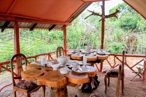 a wooden table with cups and plates on it at Sigiri Royal Point Tree House in Sigiriya
