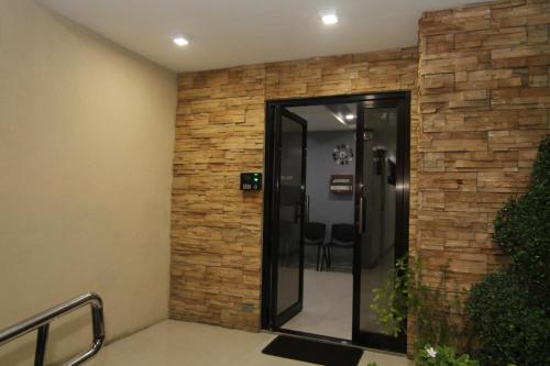 a lobby with a brick wall and a glass elevator at RF Suites in Cebu City