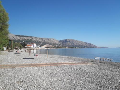 een rotsachtig strand met banken en het water bij Seafront Studios and Apartments in Chios
