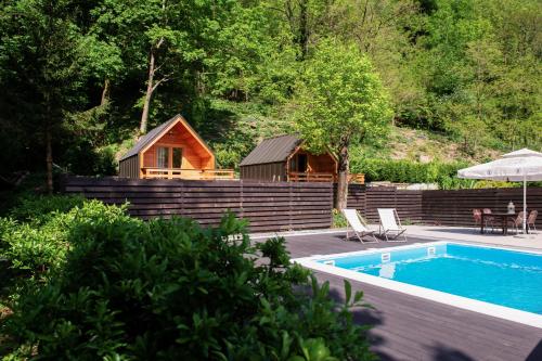 a cabin with a swimming pool and a house at Penzion Šterk in Most na Soči