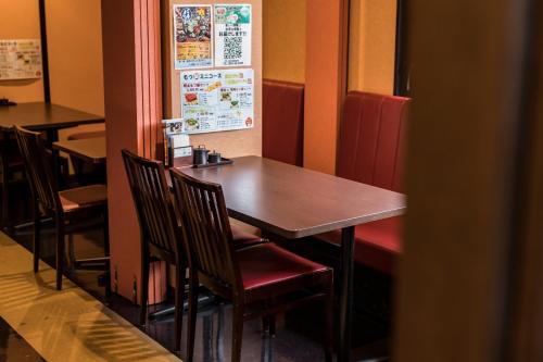 a wooden table and chairs in a restaurant at Hotel Wing International Kumamoto Yatsushiro in Yatsushiro