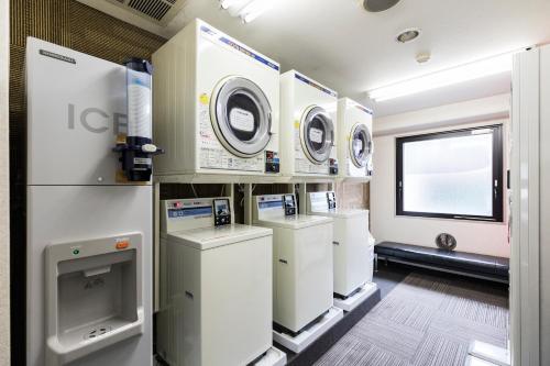 a laundry room with washing machines and a window at Hotel Wing International Kumamoto Yatsushiro in Yatsushiro