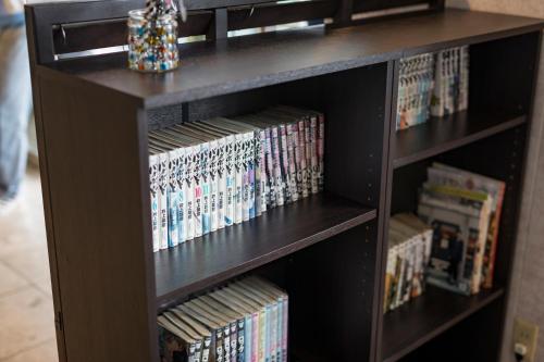 a book shelf filled with dvds and movies at Hotel Wing International Kumamoto Yatsushiro in Yatsushiro