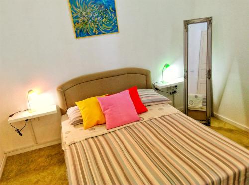 a bedroom with a bed with colorful pillows on it at Chincha Apartment in Pula
