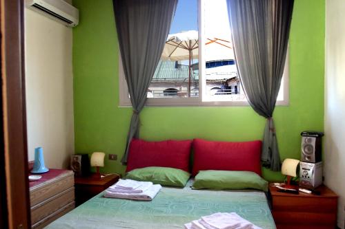 パレルモにあるBED & BREAKFAST Sweet Politeamaのベッドルーム1室(赤い枕のベッド1台、窓付)