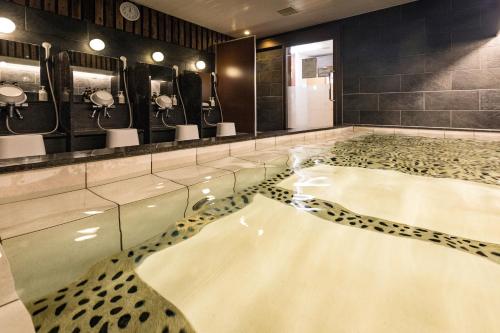 a bathroom with a large bath tub with mirrors at Hotel Wing International Kumamoto Yatsushiro in Yatsushiro