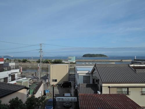 an aerial view of a city with buildings and the ocean at Minshuku Osaki in Nishio