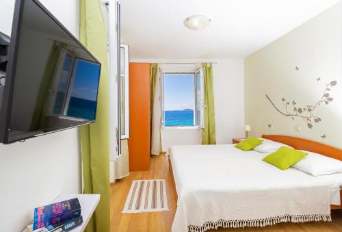 een slaapkamer met 2 bedden en een flatscreen-tv bij Villa New York in Mlini