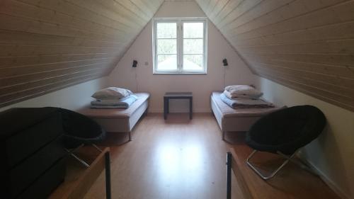 a attic room with two beds and a window at Nix at Gammel Rye in Ry