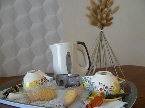 - une table avec 2 tasses de thé et des biscuits dans l'établissement Relais de la Liberte - Utah Beach, à Sainte-Marie-du-Mont