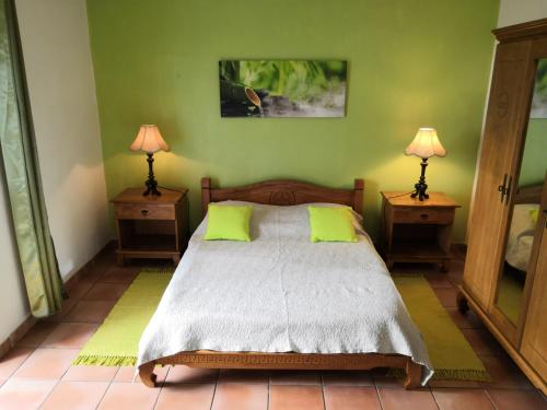 a bedroom with a bed with two night stands and two lamps at Zoiseaux Paradis in Ravine des Cabris