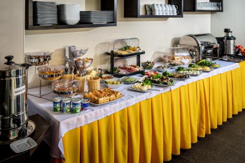 a buffet line with food on a yellow and white table at Villa Buki Pokoje & SPA in Jastrzębia Góra