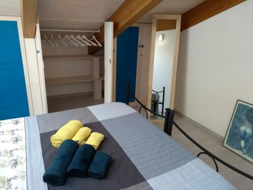 Casa vacanze “Sale di Mare” في بيسكارا: غرفة نوم مع سرير مع وسادتين زرقاء وصفراء