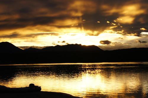 a sunset over a body of water with mountains at Theresienhof in Petschnitzen