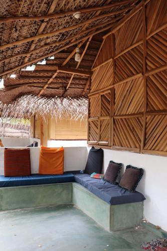a room with a bench in a building with wooden ceilings at Sun Wind Beach Kalpitiya Kite Resort in Kalpitiya