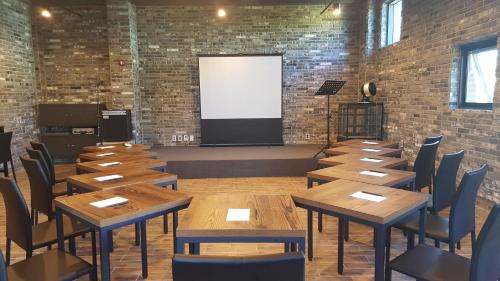 a room with wooden tables and chairs and a screen at Hotel Iam in Suncheon