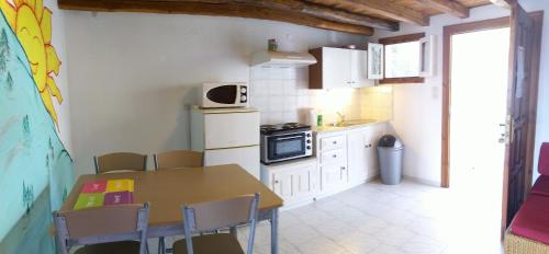 a kitchen with a table and chairs and a microwave at Amaranthos Skiathos View in Megali Ammos