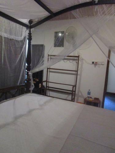 a bedroom with a bed with a canopy at Green Herbal Ayurvedic Eco-Lodge in Galle