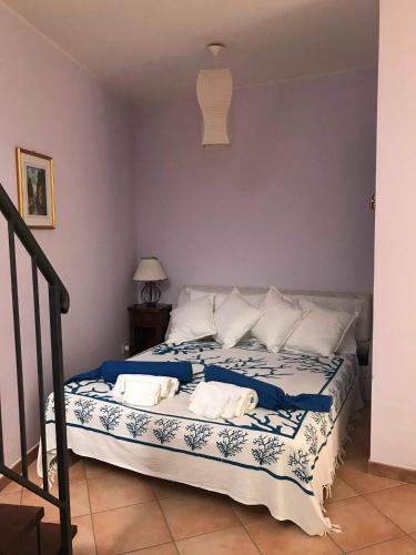 a bedroom with a bed with blue and white sheets at Casa Torre di Ligny in Favignana