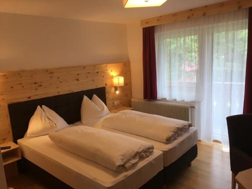 バート・ミッテルンドルフにあるGasthof Zauchenwirtのベッドルーム1室(ベッド2台、大きな窓付)