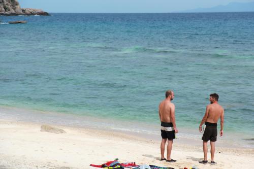 two men standing on the beach looking at the ocean at Sai Daeng Resort in Koh Tao