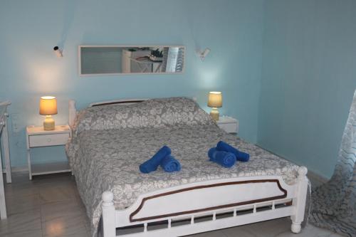 a bedroom with a bed with blue shoes on it at Madalenas B&B in Pelekas