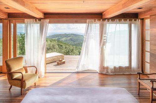 a bedroom with a large window with a view at Castello Di Vicarello in Sasso dʼOmbrone